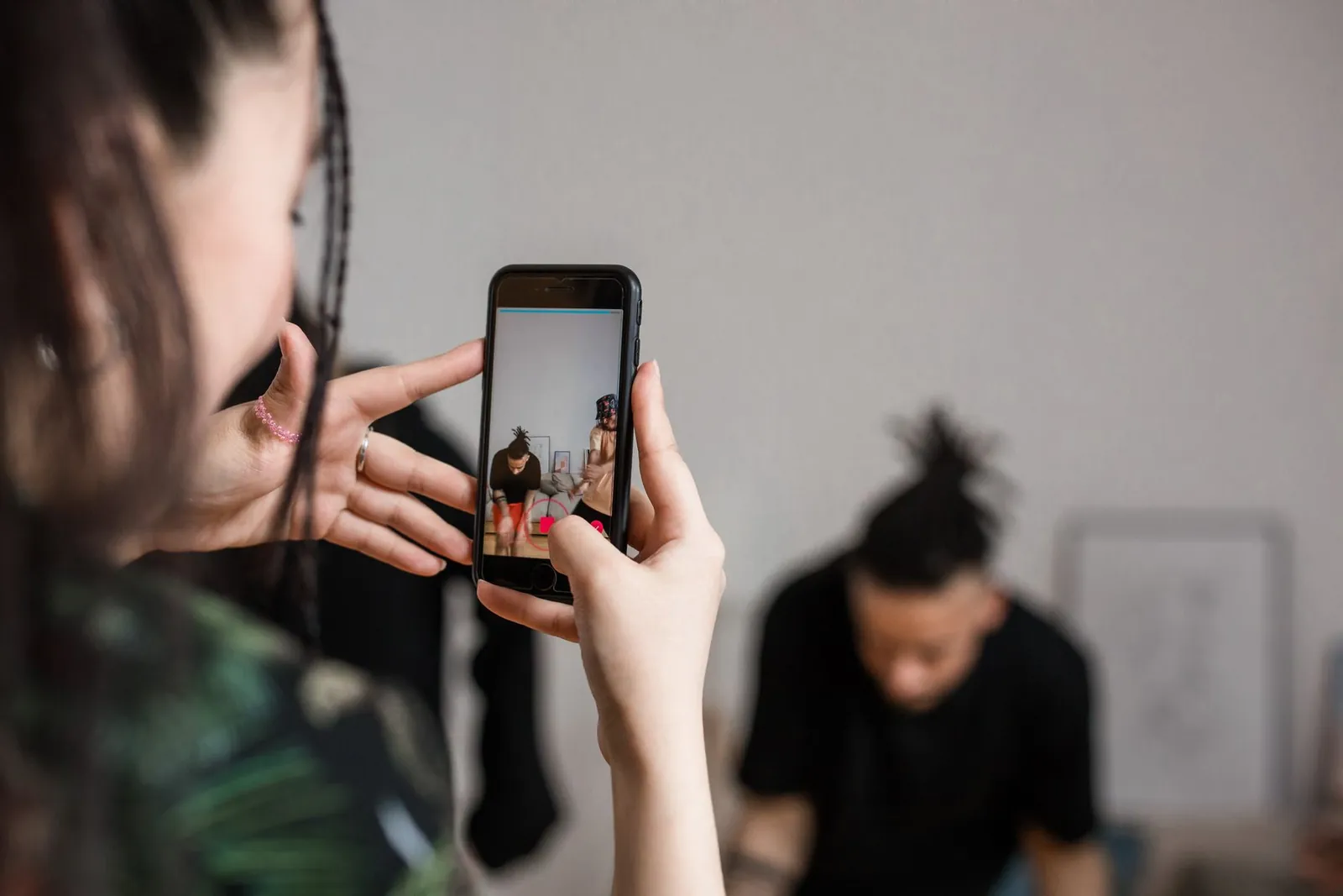 Mitarbeiterin filmt einen Kollegen mit dem Handy